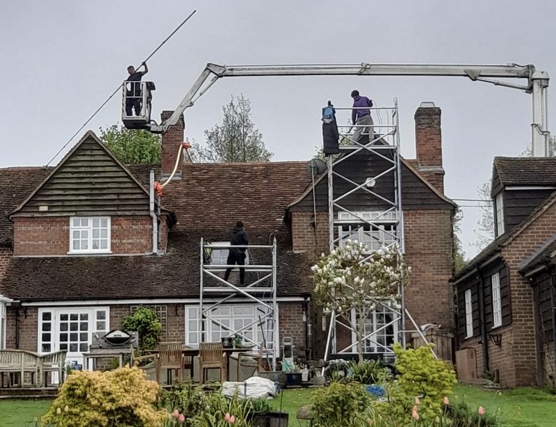 The Moss Cleaners using cherry picker and scaffolding to clean roof safely and professionally in Winchcombe, Gloucestershire